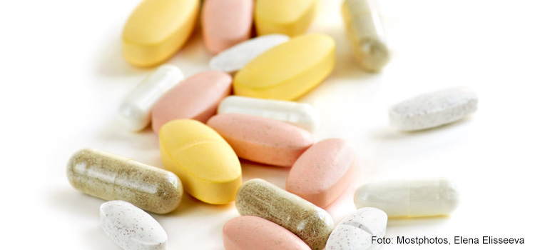 Bild på rosa, vita och gula tabletter som kan vara kosttillskott.
